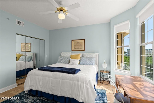 bedroom with light wood-type flooring, ceiling fan, and a closet