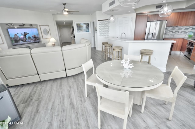 dining area with ceiling fan and light hardwood / wood-style flooring