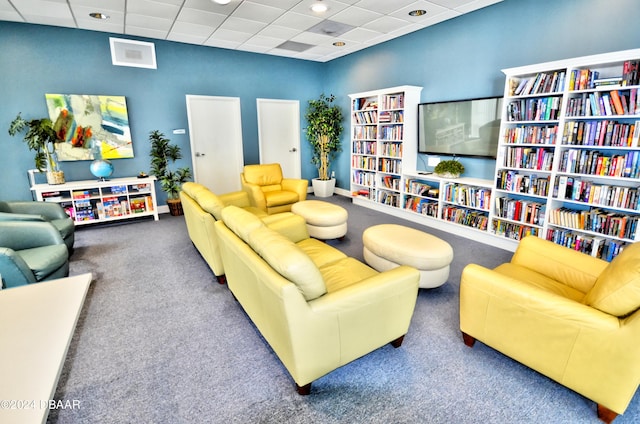 interior space featuring a paneled ceiling and carpet flooring