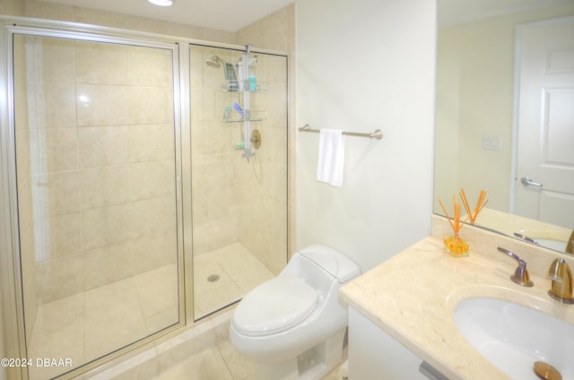 bathroom featuring a shower with door, vanity, toilet, and tile patterned floors