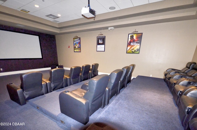 carpeted home theater with a paneled ceiling