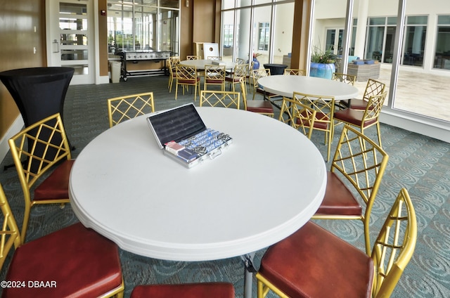 dining room with a wealth of natural light and dark carpet