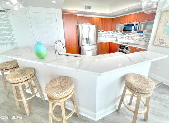 kitchen featuring kitchen peninsula, a breakfast bar, and stainless steel appliances