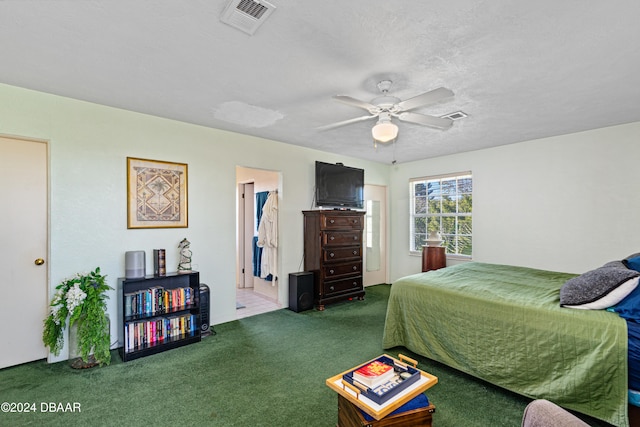 bedroom with ceiling fan, dark carpet, and a textured ceiling