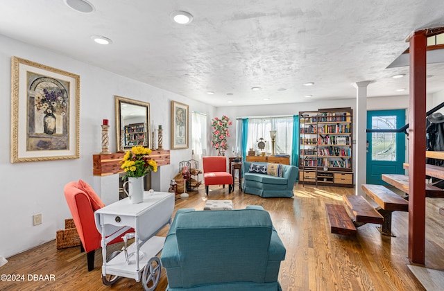 living room featuring hardwood / wood-style floors and decorative columns