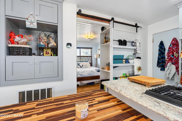 bedroom featuring a barn door and light wood-type flooring