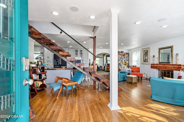 living room with light wood-type flooring and decorative columns