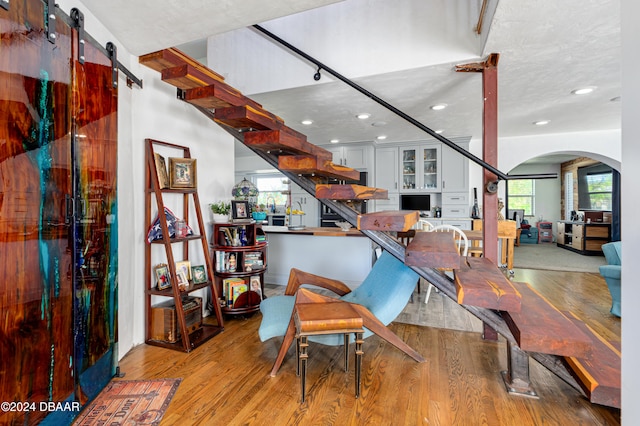 dining room featuring a barn door and light hardwood / wood-style flooring