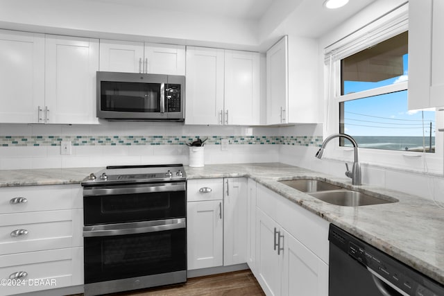 kitchen with decorative backsplash, white cabinetry, sink, and appliances with stainless steel finishes