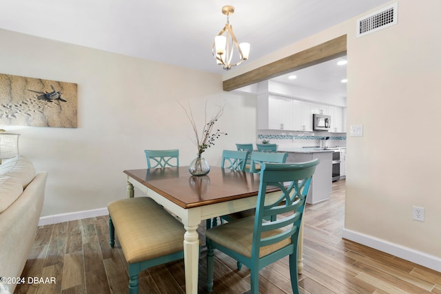 dining room featuring light hardwood / wood-style flooring and an inviting chandelier