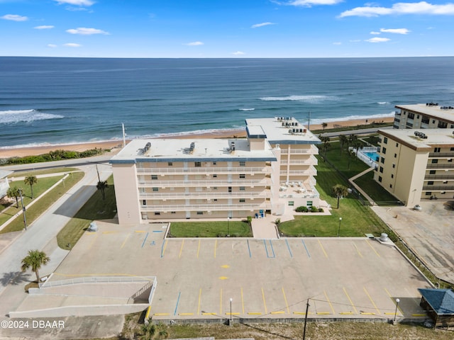 drone / aerial view featuring a beach view and a water view