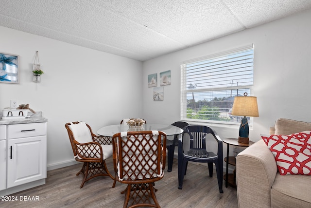 dining space with light hardwood / wood-style flooring and a textured ceiling