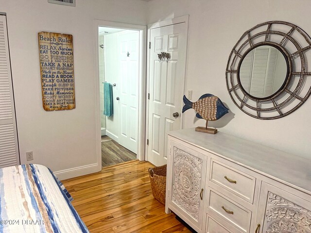 laundry area with stacked washing maching and dryer and light hardwood / wood-style floors