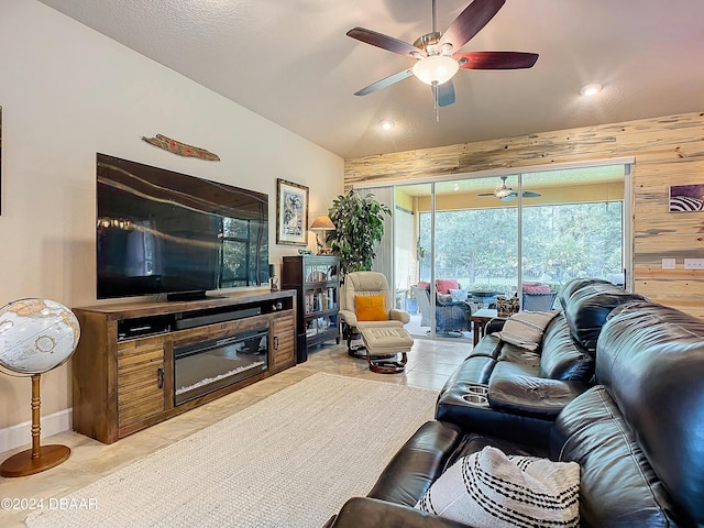 645 Elk River Dr, Ormond Beach, FL 32174 - living area featuring wooden walls, light tile patterned floors, a ceiling fan, lofted ceiling, and a glass covered fireplace
