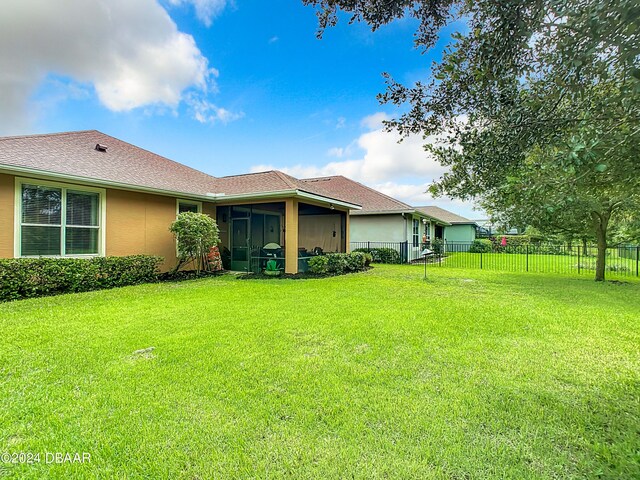 645 Elk River Dr, Ormond Beach, FL 32174 - rear view of house with stucco siding, a lawn, fence, and a sunroom