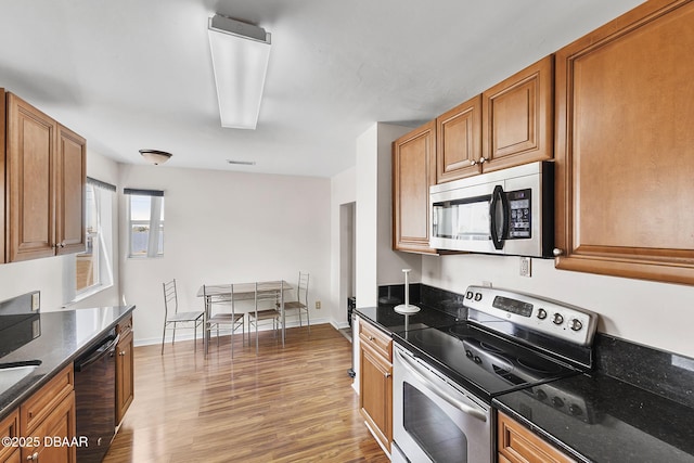 kitchen featuring brown cabinetry, wood finished floors, and stainless steel appliances