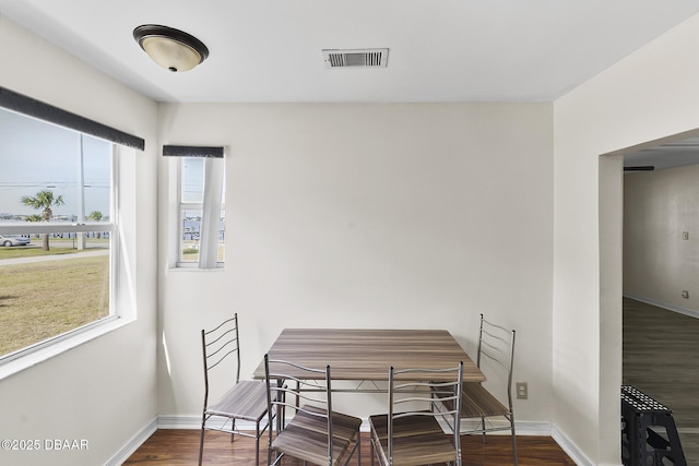 dining space featuring wood finished floors, visible vents, and a healthy amount of sunlight