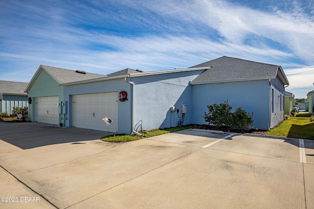 613 Good Life Way, Daytona Beach, FL 32124 - view of side of home with an attached garage, stucco siding, driveway, and roof with shingles