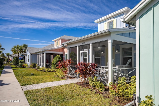 613 Good Life Way, Daytona Beach, FL 32124 - view of property exterior with a sunroom, a yard, and board and batten siding