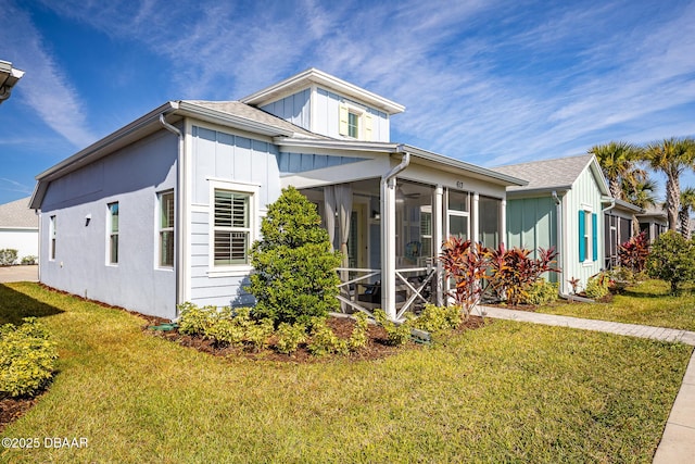 613 Good Life Way, Daytona Beach, FL 32124 - view of front of property with board and batten siding, a front yard, and a sunroom