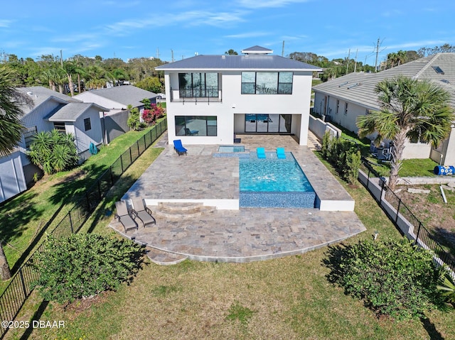 back of house featuring a patio, a balcony, a fenced backyard, and stucco siding