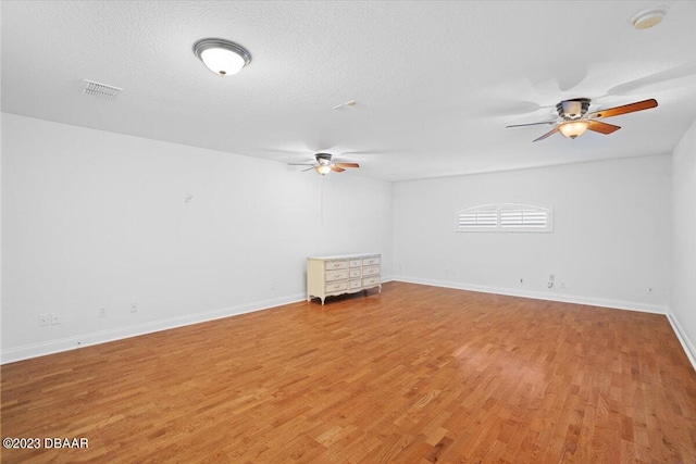 empty room featuring ceiling fan, wood-type flooring, and a textured ceiling