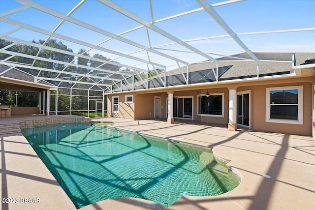 view of pool featuring glass enclosure and a patio