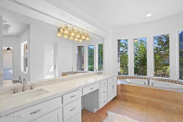 bathroom featuring vanity, tile patterned flooring, and a relaxing tiled tub