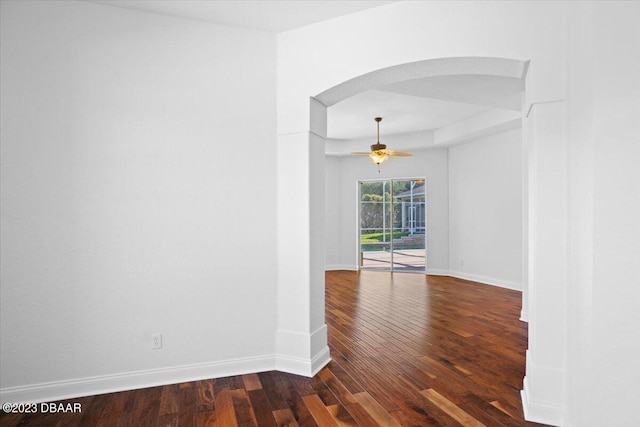 empty room with dark hardwood / wood-style flooring and ceiling fan