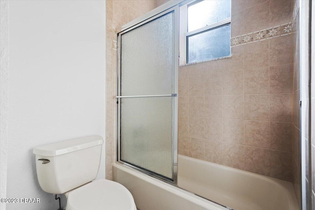 bathroom featuring bath / shower combo with glass door and toilet