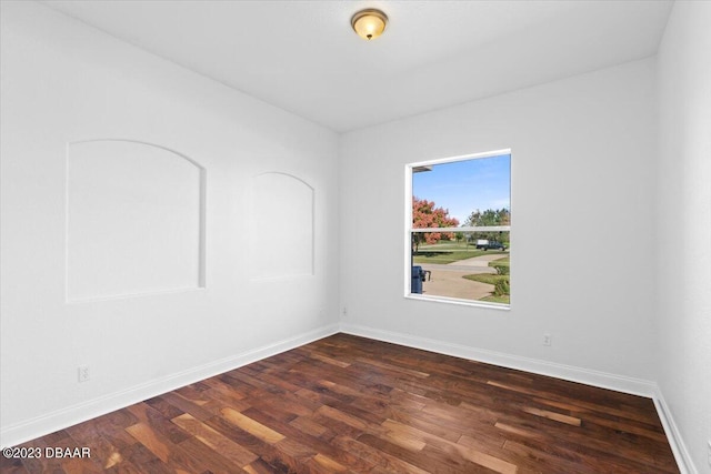 spare room with dark wood-type flooring