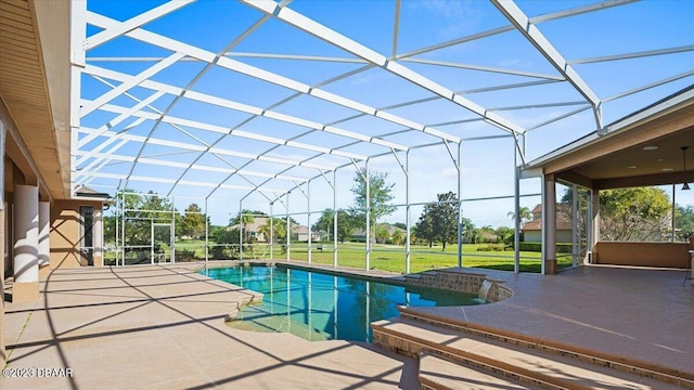 view of swimming pool featuring glass enclosure, a patio, and a yard