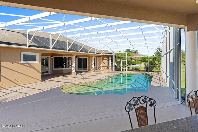 view of pool with glass enclosure and a patio