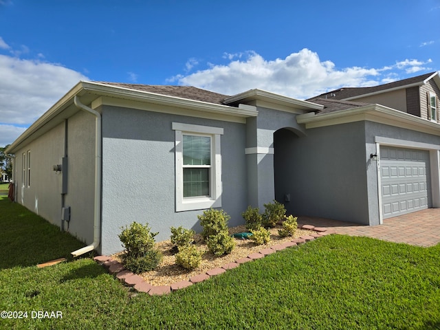 view of side of home with a lawn and a garage