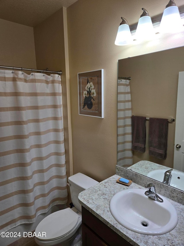 bathroom with vanity, a textured ceiling, and toilet