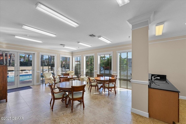 tiled dining area featuring a textured ceiling, crown molding, and french doors