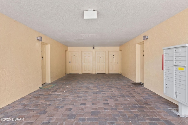 4600 E Moody Blvd Unit 14-O, Bunnell, FL 32110 - unfurnished room with a textured ceiling, brick flooring, a textured wall, and mail area