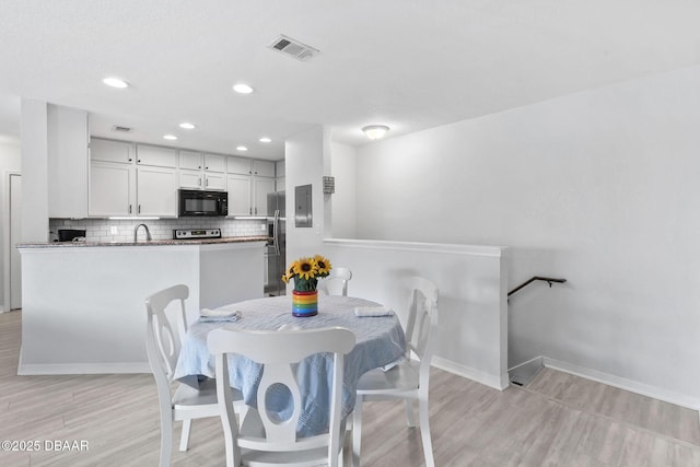 4600 E Moody Blvd Unit 14-O, Bunnell, FL 32110 - dining space featuring light wood-type flooring and recessed lighting