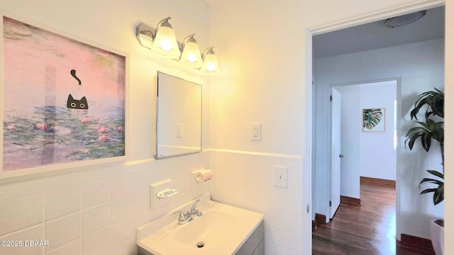 119 Rogers Park Dr, Ormond Beach, FL 32174 - bathroom featuring vanity, wood finished floors, tile walls, and a wainscoted wall