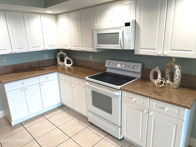 3145 S Atlantic Ave Unit 401, Daytona Beach, FL 32118 - kitchen with white appliances, white cabinetry, and light tile patterned floors