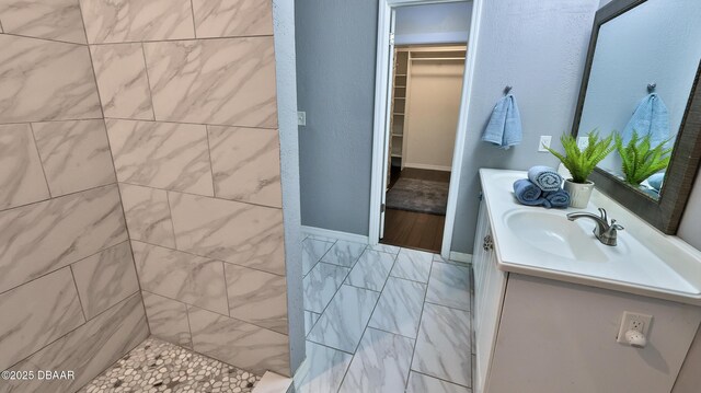 103 Cone Rd, Ormond Beach, FL 32174 - bathroom with vanity, a spacious closet, and a tile shower