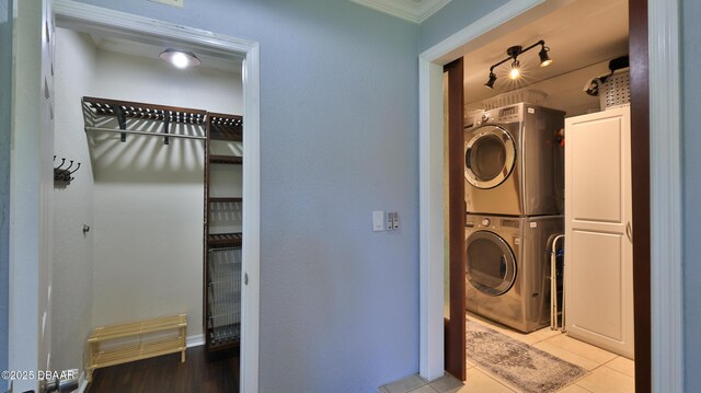 103 Cone Rd, Ormond Beach, FL 32174 - laundry room featuring stacked washer / dryer, ornamental molding, and tile patterned flooring