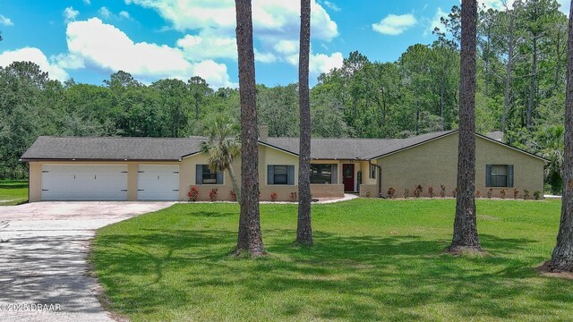 103 Cone Rd, Ormond Beach, FL 32174 - view of front of house featuring concrete driveway, an attached garage, a front yard, and stucco siding