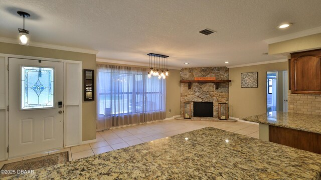 103 Cone Rd, Ormond Beach, FL 32174 - foyer featuring light tile patterned floors, a textured ceiling, crown molding, a stone fireplace, and recessed lighting