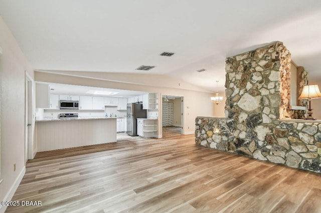2421 Needle Palm Dr, Edgewater, FL 32141 - unfurnished living room featuring lofted ceiling, light wood finished floors, baseboards, and a chandelier
