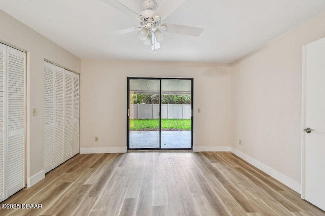 2421 Needle Palm Dr, Edgewater, FL 32141 - unfurnished bedroom with access to exterior, wood finished floors, multiple closets, baseboards, and a ceiling fan