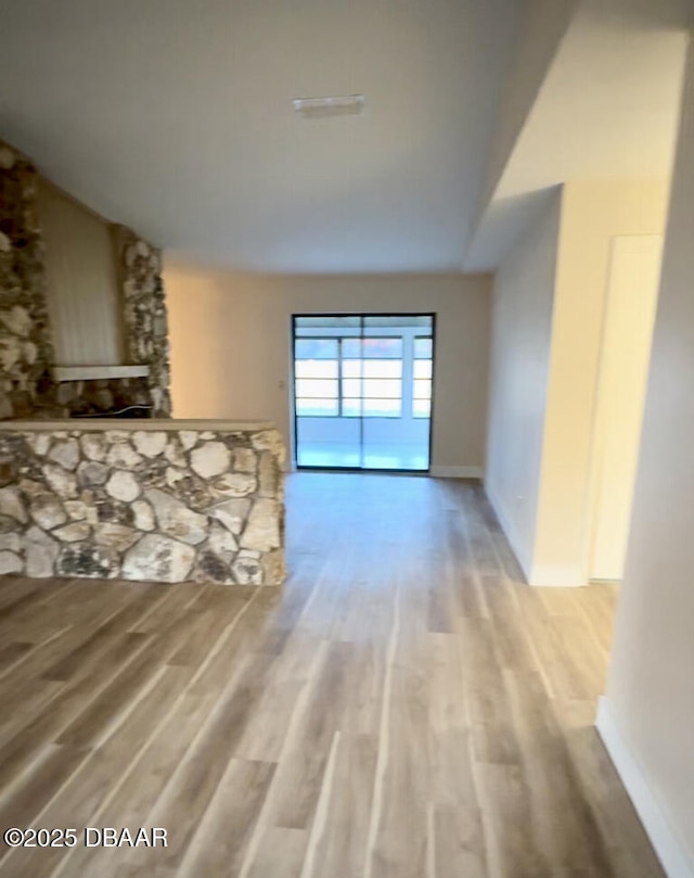 2421 Needle Palm Dr, Edgewater, FL 32141 - unfurnished living room featuring lofted ceiling, light wood finished floors, baseboards, and a large fireplace