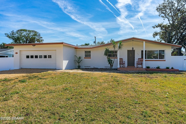 ranch-style home featuring a garage, a front yard, and covered porch