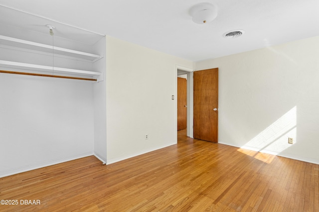 unfurnished bedroom featuring hardwood / wood-style flooring and a closet