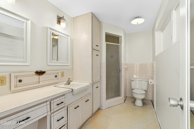 bathroom with vanity, an enclosed shower, tile walls, and toilet